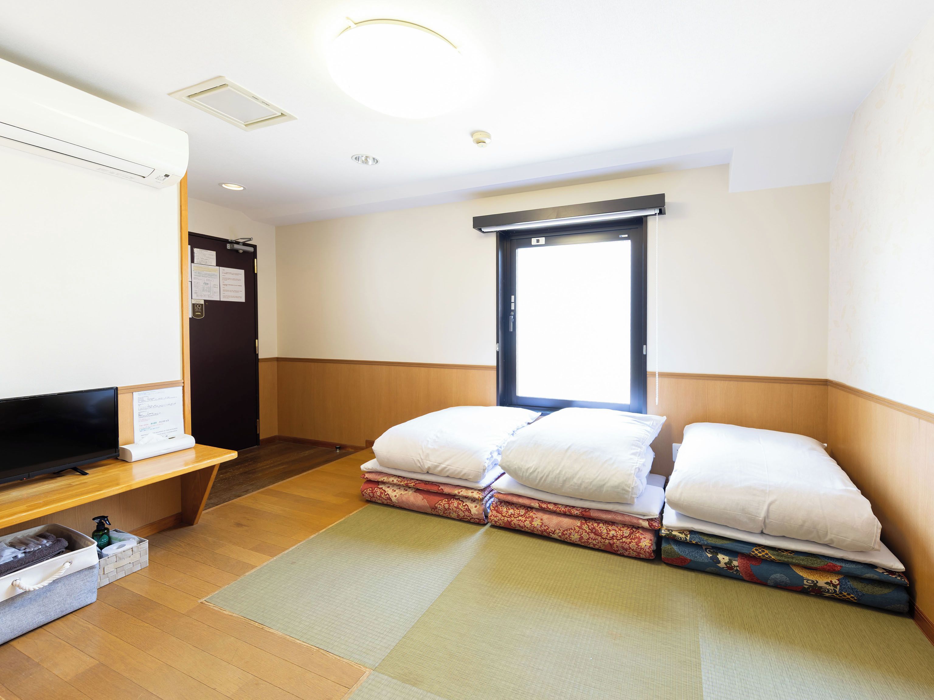 Une chambre d’hôtel avec un lit, une télévision, un bureau et une fenêtre.