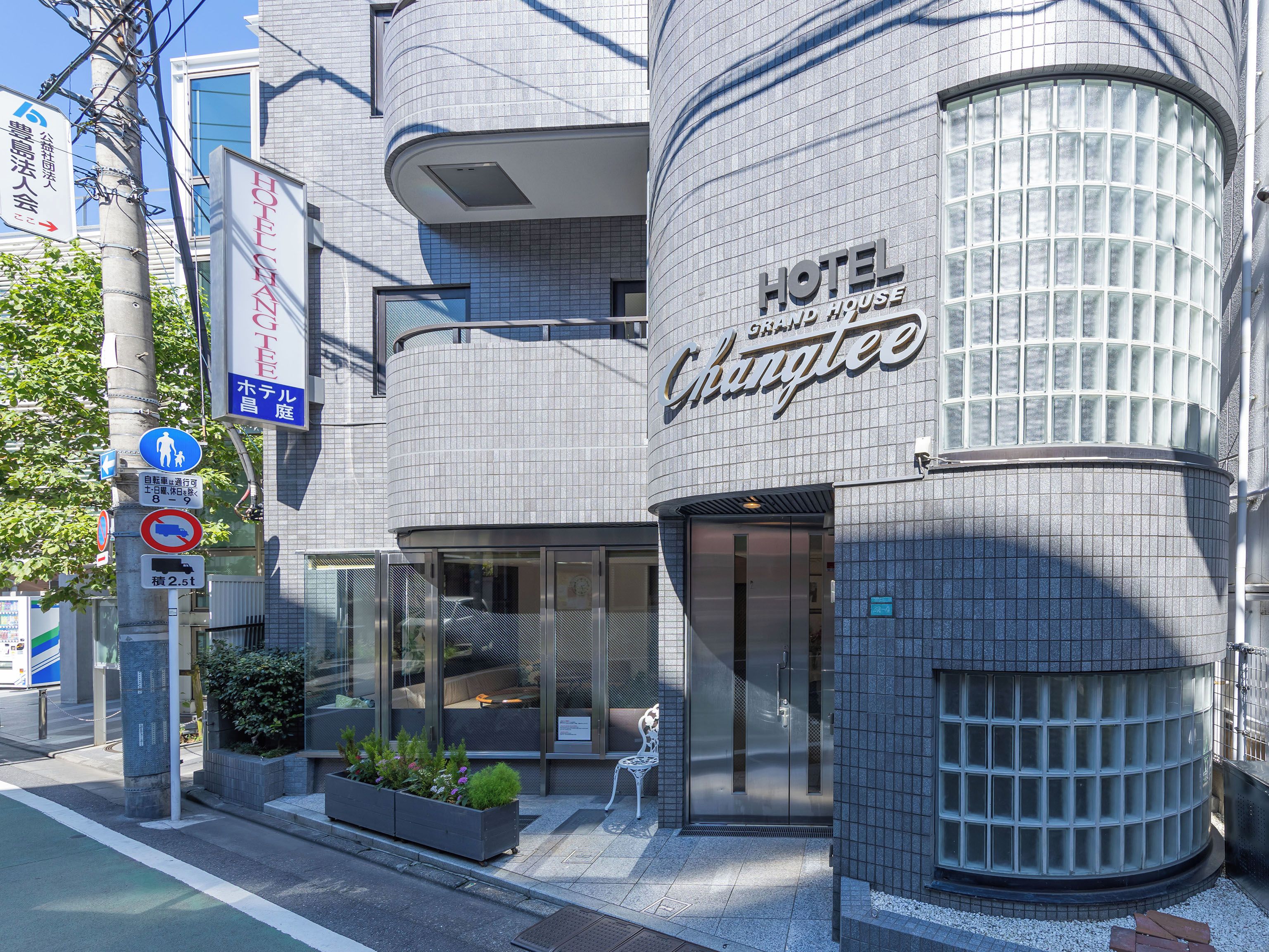 A modern hotel with a curved facade, large windows, and a sign indicating a hotel named 'Hotel Changhee.'