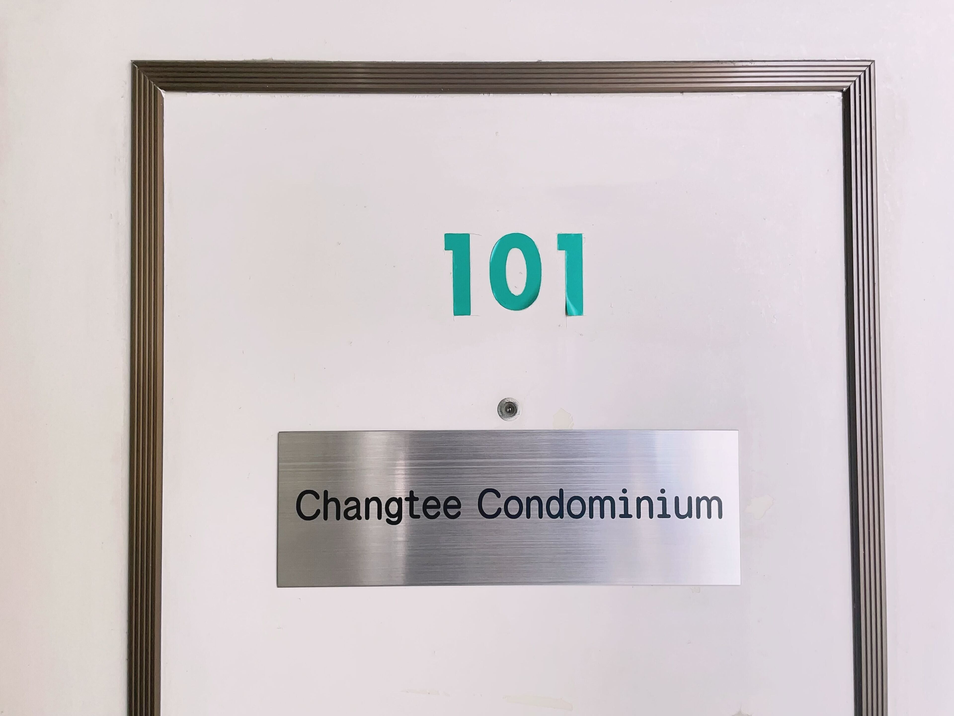 Segnale con il numero 101 e la scritta 'Changtee Condominium'.