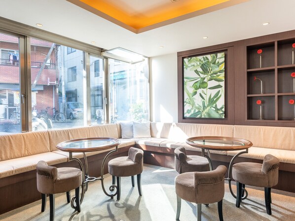 Een modern interieur met een bank, twee ronde tafels en zes stoelen.