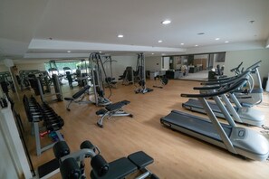 A gym with various exercise equipment, including treadmills, weight machines, and free weights. - La Breza Hotel (Quezon City)