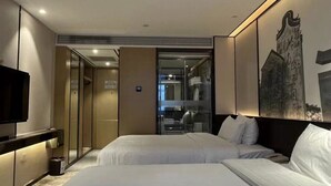 Ein Hotelzimmer mit zwei Betten, einem Fernseher, einem Spiegel und einem Gemälde an der Wand.