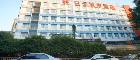 A multi-story hotel with a modern facade, featuring a prominent logo and signage.