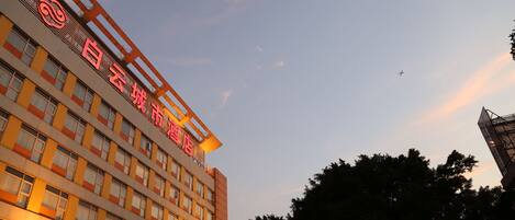 A multi-story hotel with a prominent red sign on the facade.