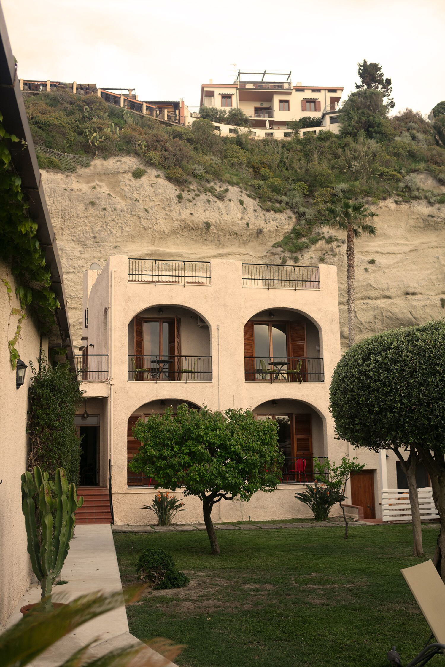 A two-story building with a flat roof, arched windows, and balconies.
