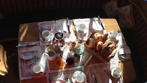 A table set for breakfast with various dishes, cups, and utensils.