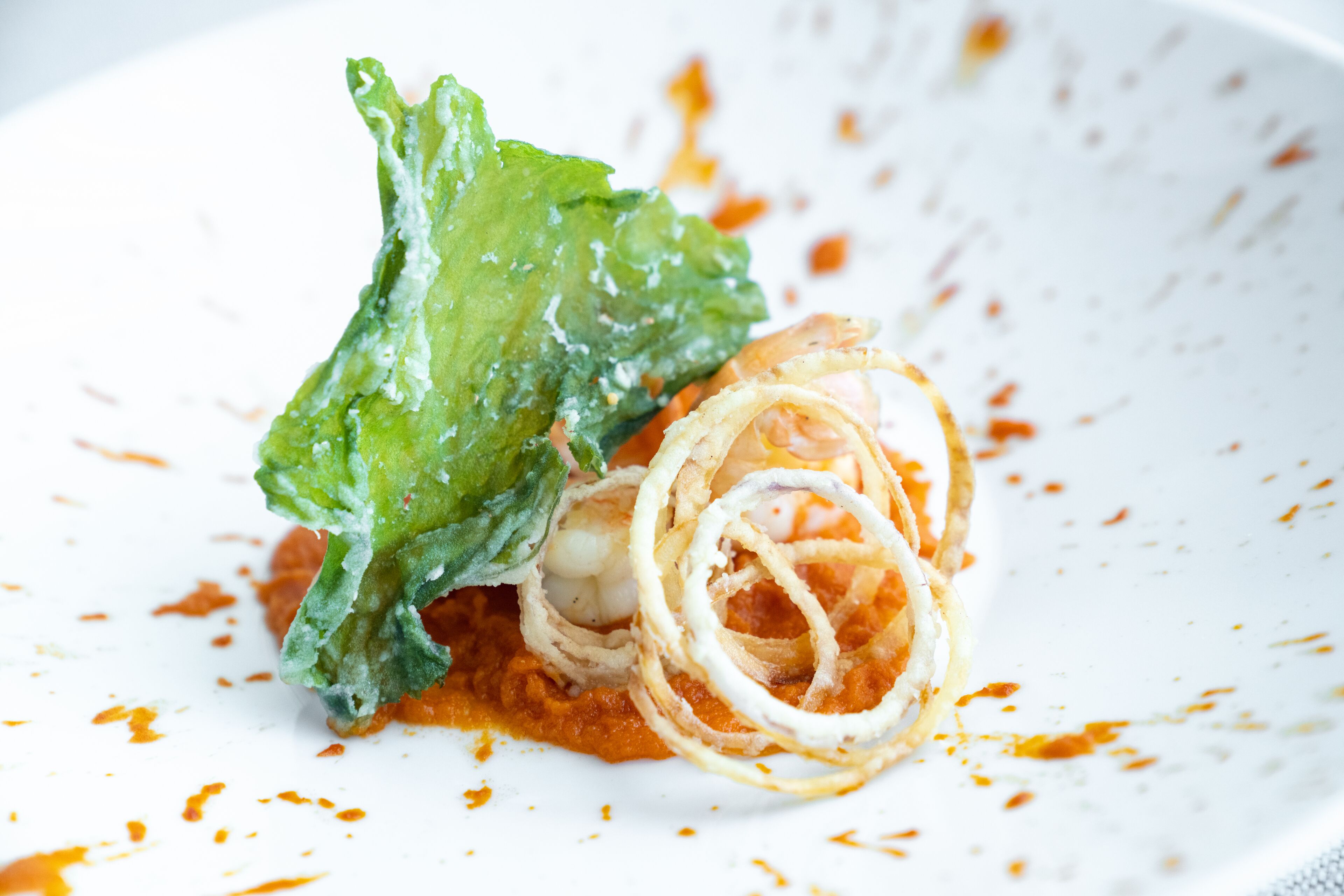 Un piatto con un'insalata, forse contenente lattuga e cipolle, condita con una salsa cremosa.