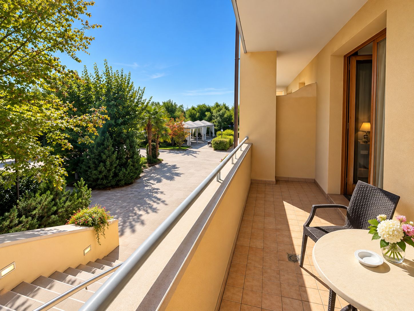Un balcone con vista su un giardino e un edificio sullo sfondo.