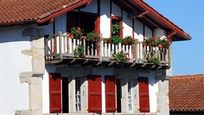 A two-story building with a balcony, red shutters, and a tiled roof. - Village Club Le Saint Ignace (Ascain)