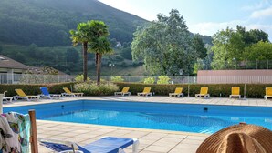 A poolside breakfast setup with a tray of food, a drink, and a hat. - Village Club Le Saint Ignace (Ascain)
