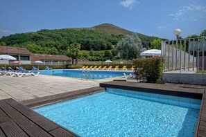 Una piscina al aire libre, tumbonas