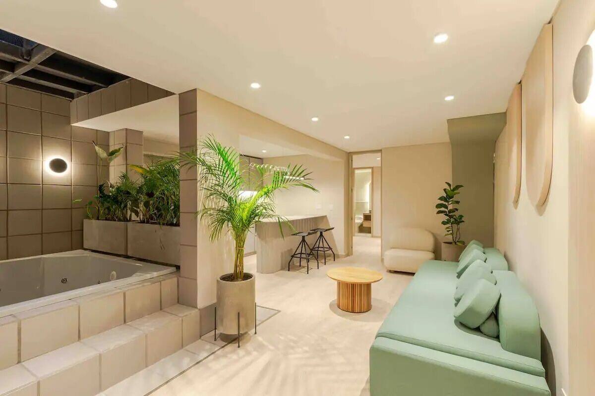 A modern interior with a spa area, including a bathtub, seating, and potted plants.