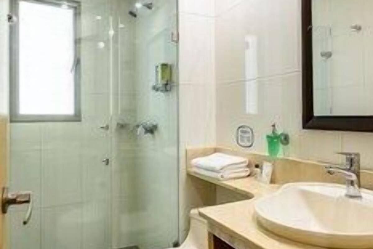 A bathroom with a toilet, sink, and shower.