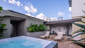 A rooftop pool area with a hot tub, lounge chairs, and exercise equipment. - Hotel Lincoln (Medellín)