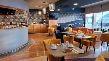 Un restaurante con mostrador, zona de estar y vistas al exterior.