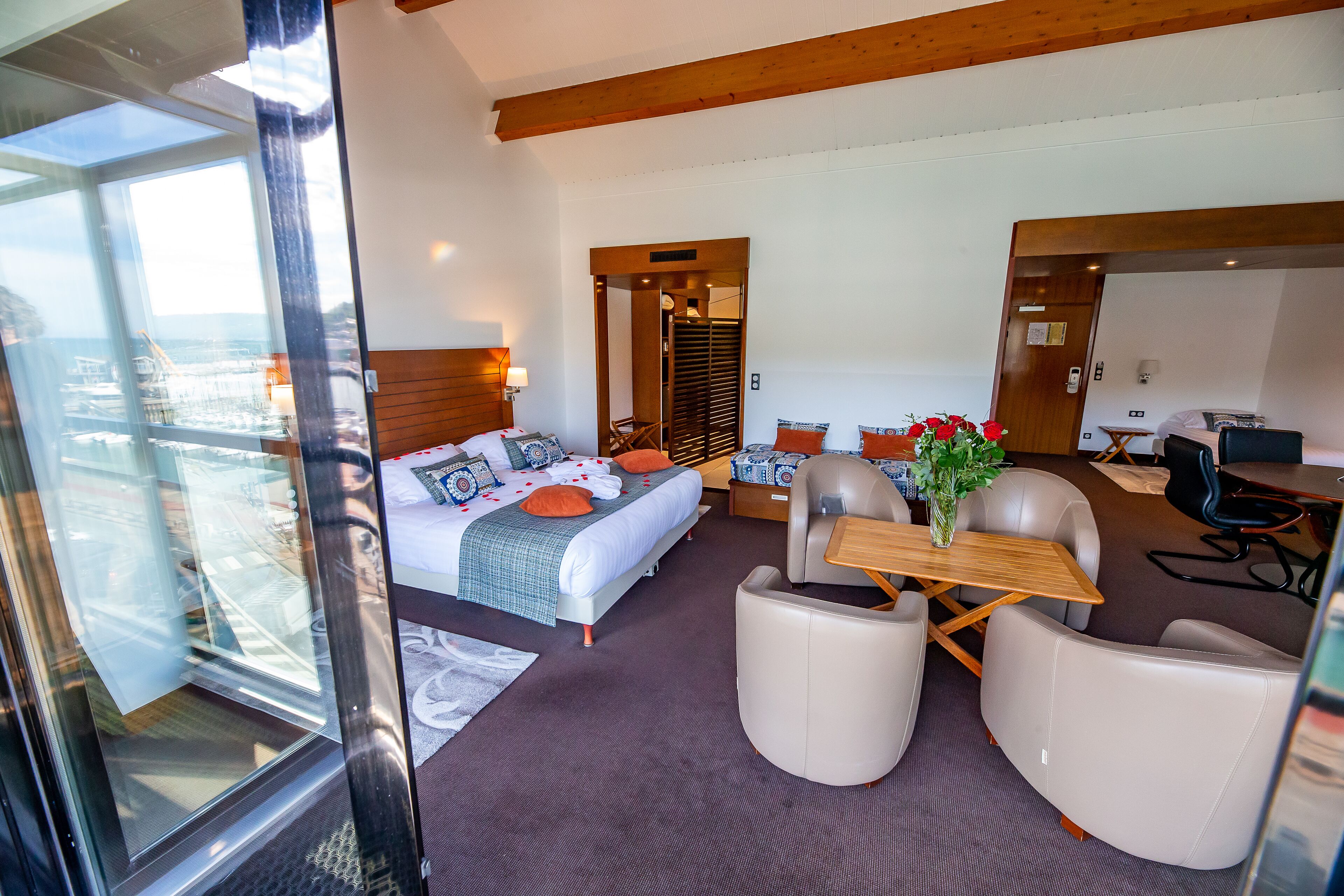 Una habitación de hotel moderna con una cama grande, un escritorio y una zona de estar cómoda.