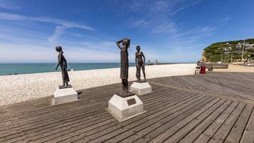 Walk along the boardwalk to the sandy beach, where bronze statues stand guard.
