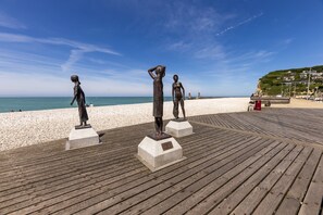 A wooden boardwalk with three bronze statues. - Le Grand Pavois (Fecamp)