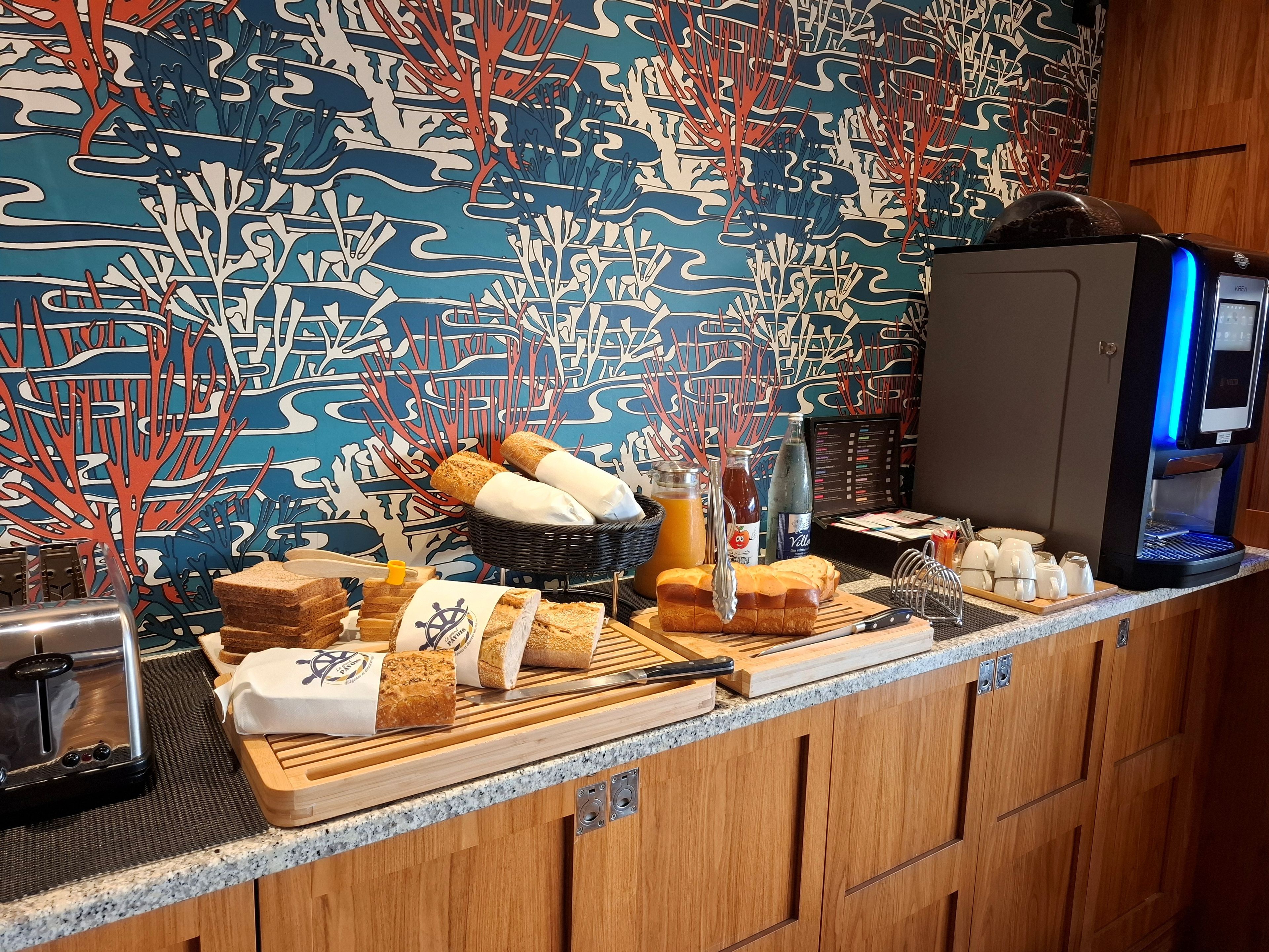 A breakfast buffet with bread, pastries, and beverages.
