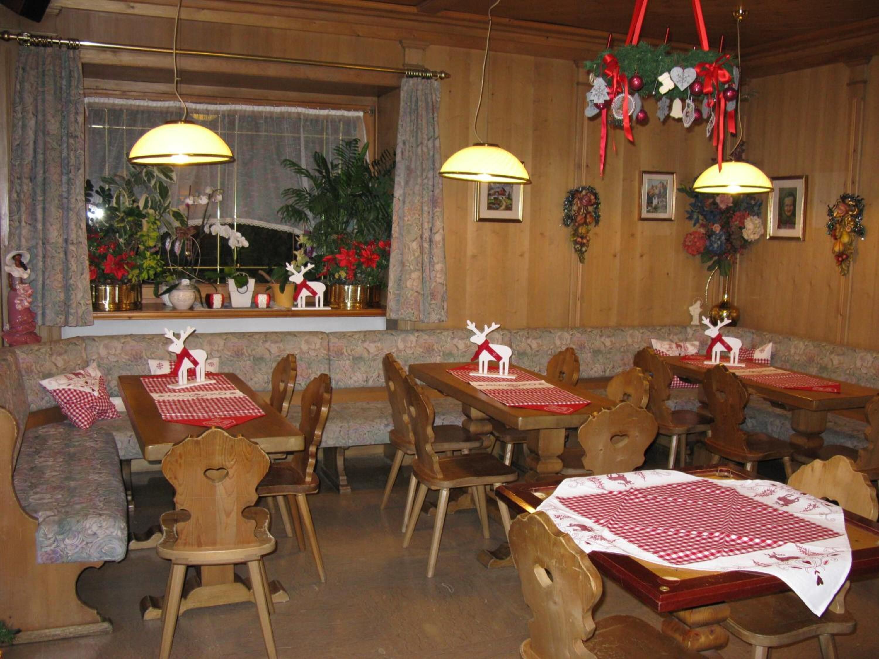 Un restaurante acogedor con paredes de madera y mesas dispuestas con manteles a cuadros rojos y blancos.