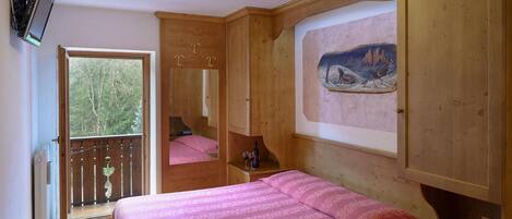 Un dormitorio con cama, un cuadro y un armario de madera.