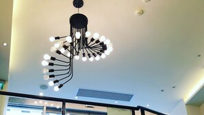 A modern interior with a unique chandelier, glass railings, and a view of the outside. - Single inn kaohsiung Lisen Hostel (Kaohsiung)