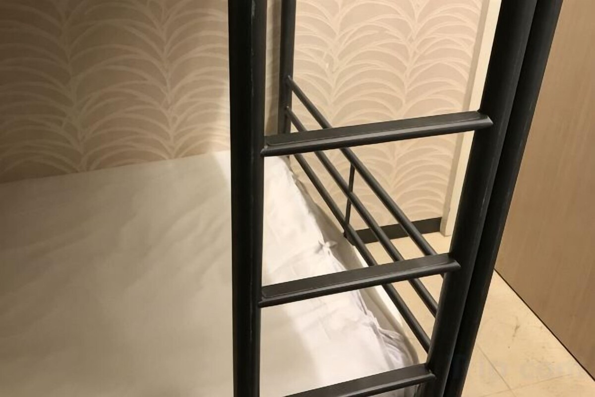 A bed with a metal frame and a white mattress.