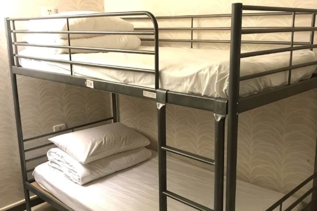 A bunk bed with a mattress, pillows, and a metal frame.