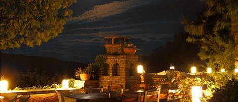 An outdoor dining area with a brick structure, potted plants, and candles.