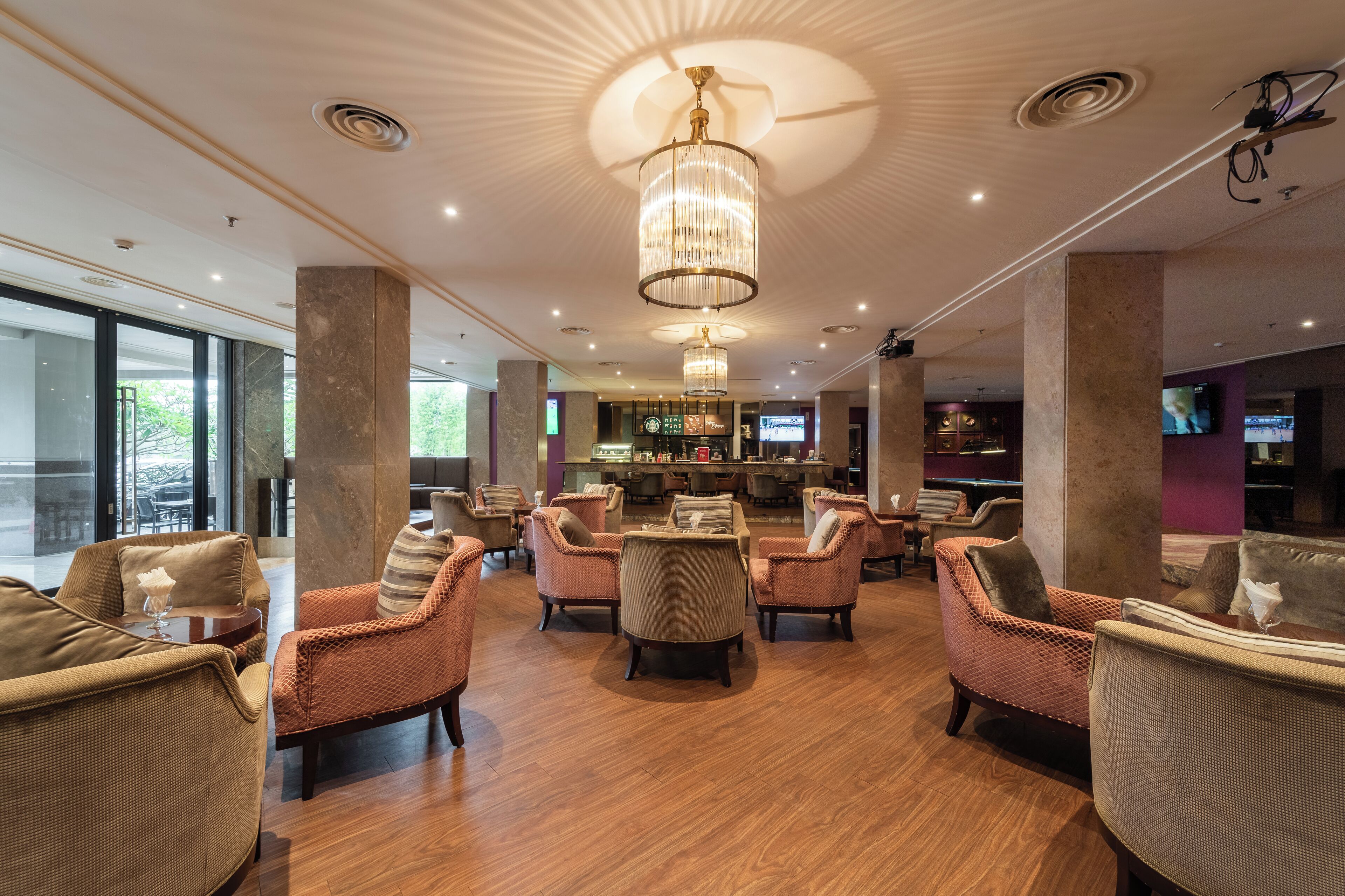 A spacious lounge area with multiple seating options, a bar, and a television screen.