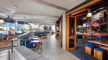 A modern bar area with seating and a television screen.