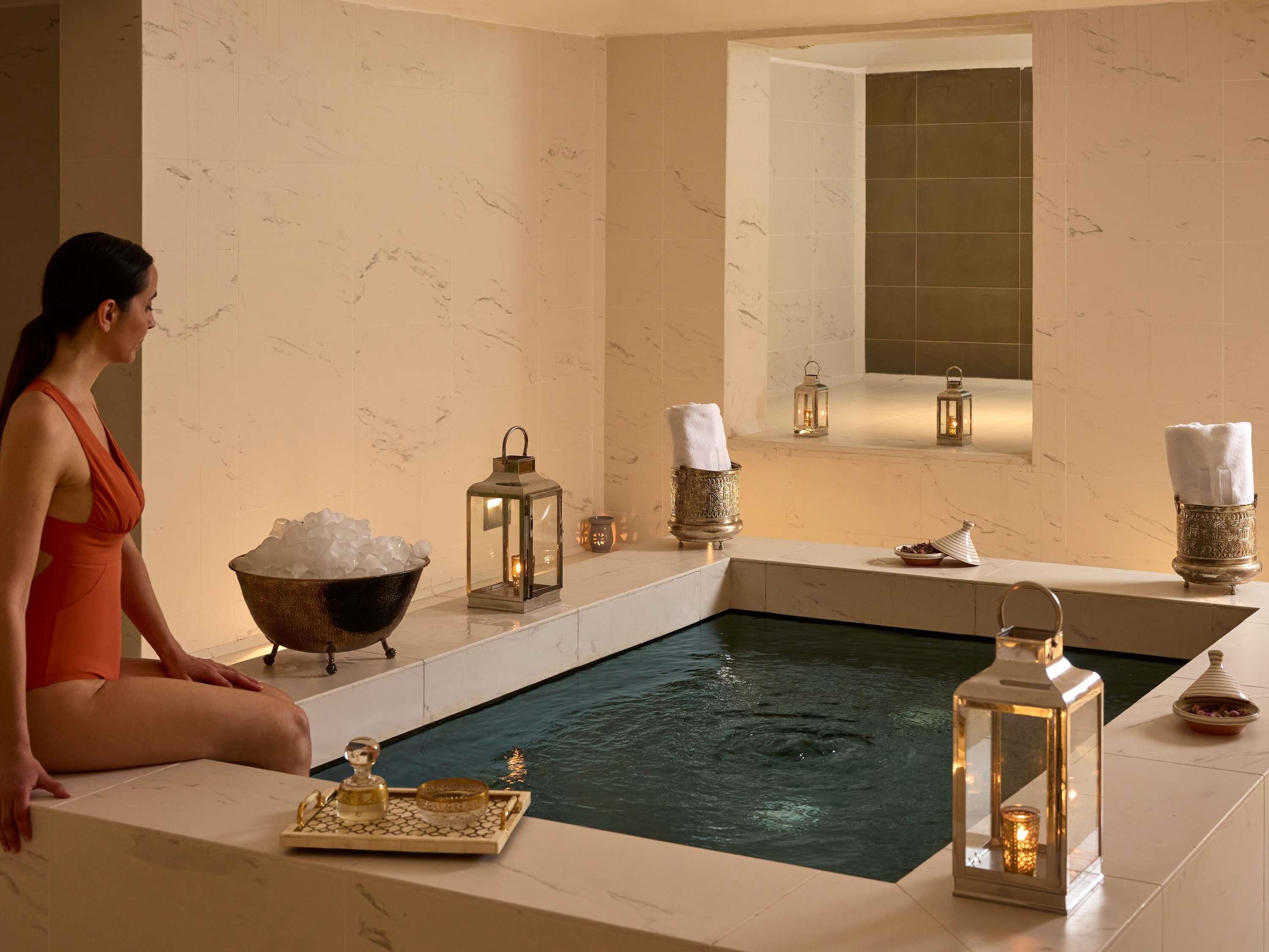 Un área de spa con una bañera de hidromasaje, faroles decorativos y un bol de hielo.