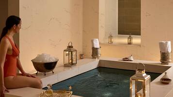 Un área de spa con una bañera de hidromasaje, faroles decorativos y un bol de hielo.