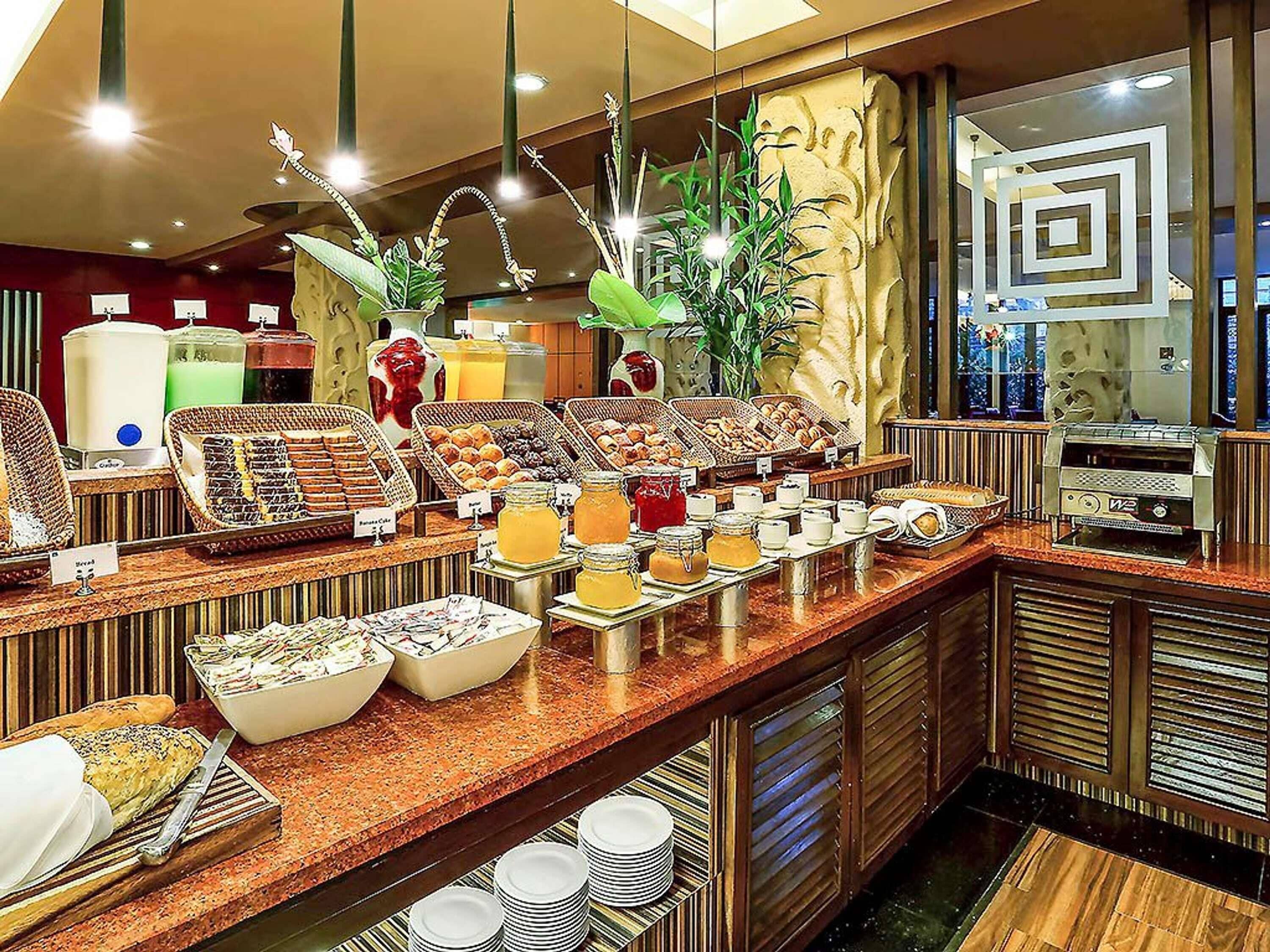 A buffet with various food items, a coffee machine, and a juice dispenser.