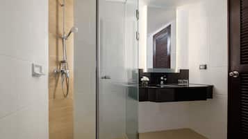 A modern bathroom with a glass-enclosed shower, a black sink vanity, and a wooden door.