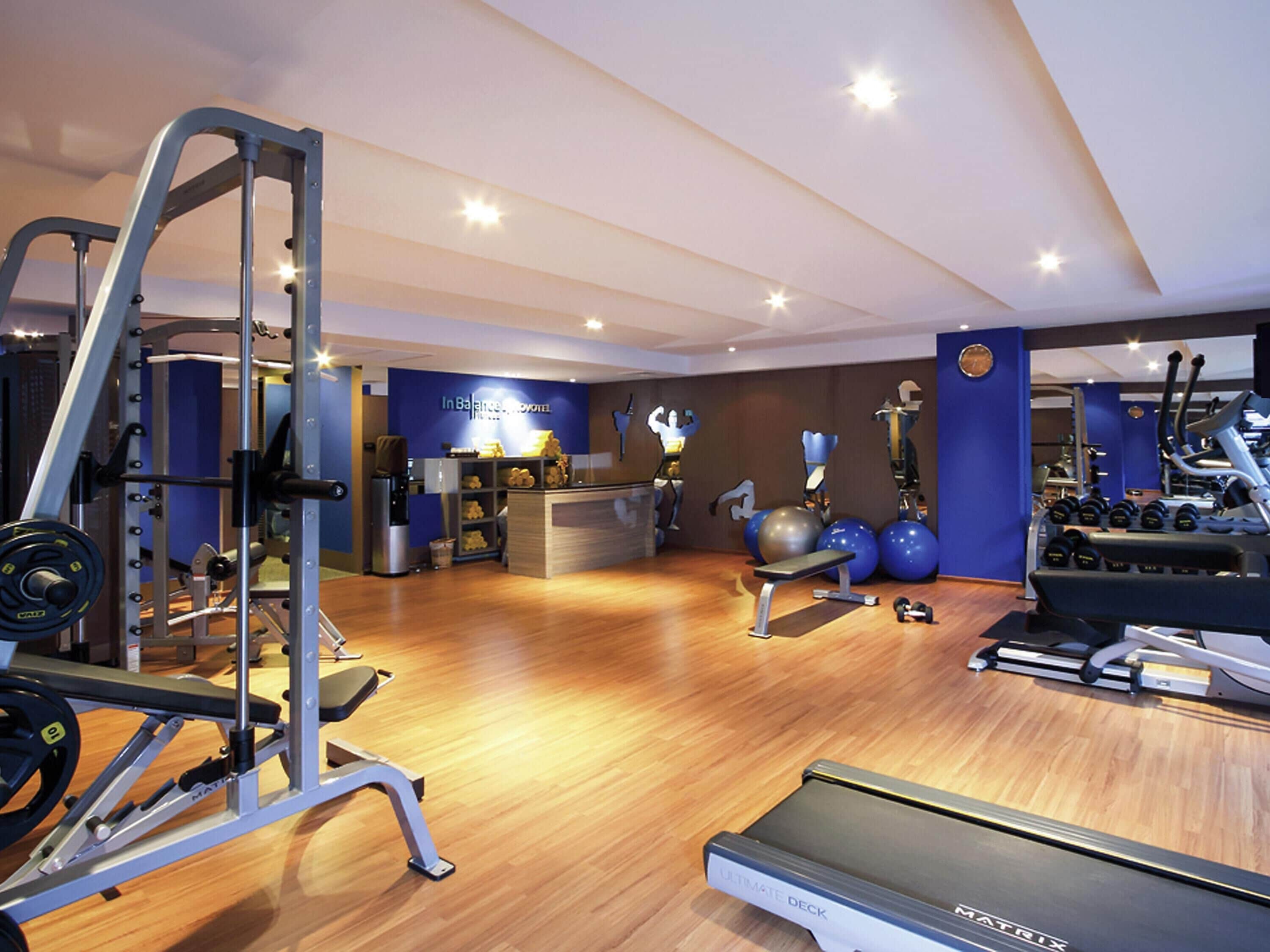 A gym with cardio equipment, weightlifting stations, and exercise balls.