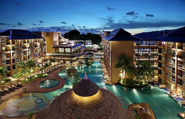 Een buitenzwembad, parasols bij het zwembad en ligstoelen