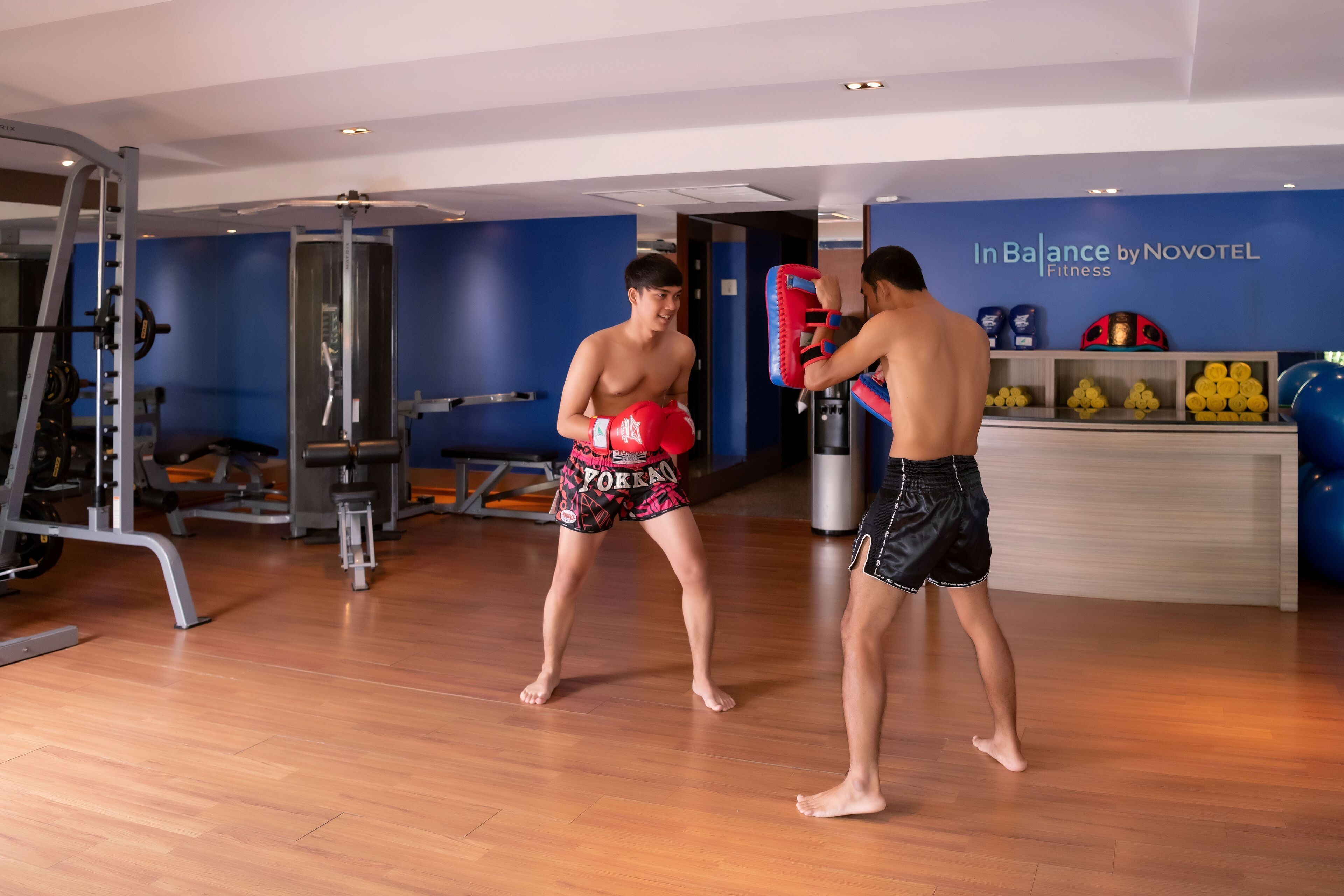 A gym with exercise equipment and a punching bag.