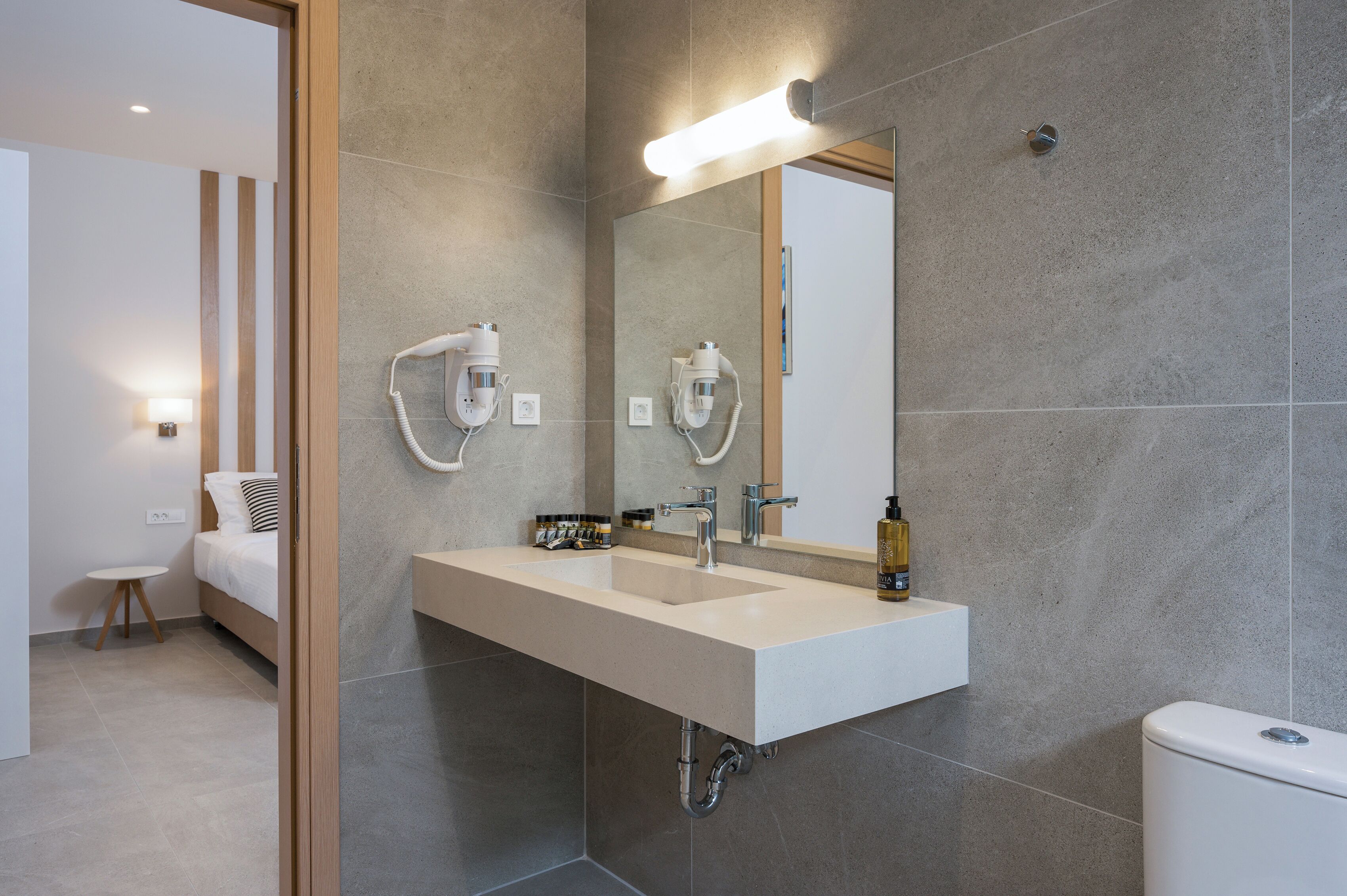 Un baño moderno con lavamanos doble, un espejo grande y un secador de pelo.