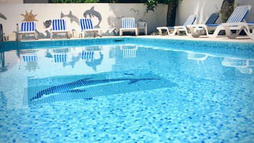 Piscine extérieure en saison, chaises longues