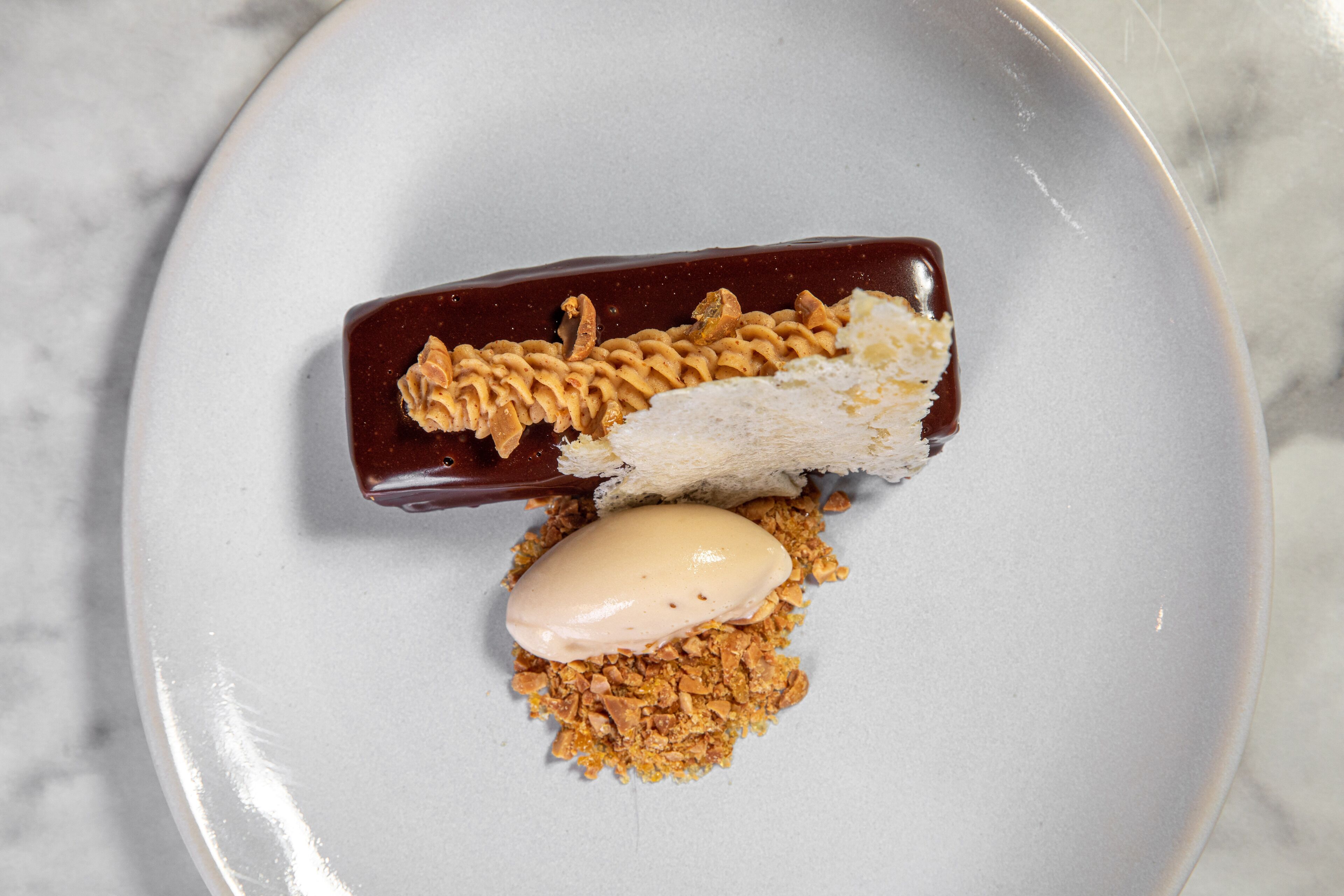 Un postre sobre un plato sobre fondo blanco.