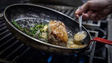 Una sartén con un trozo de carne asándose en una parrilla.