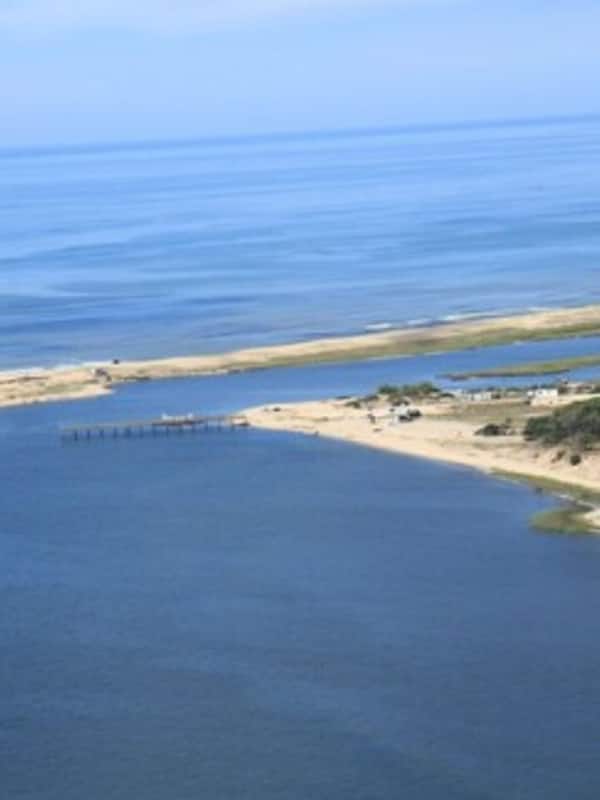 Na praia, espreguiçadeiras, guarda-sóis, toalhas de praia