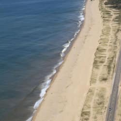Na praia, espreguiçadeiras, guarda-sóis, toalhas de praia