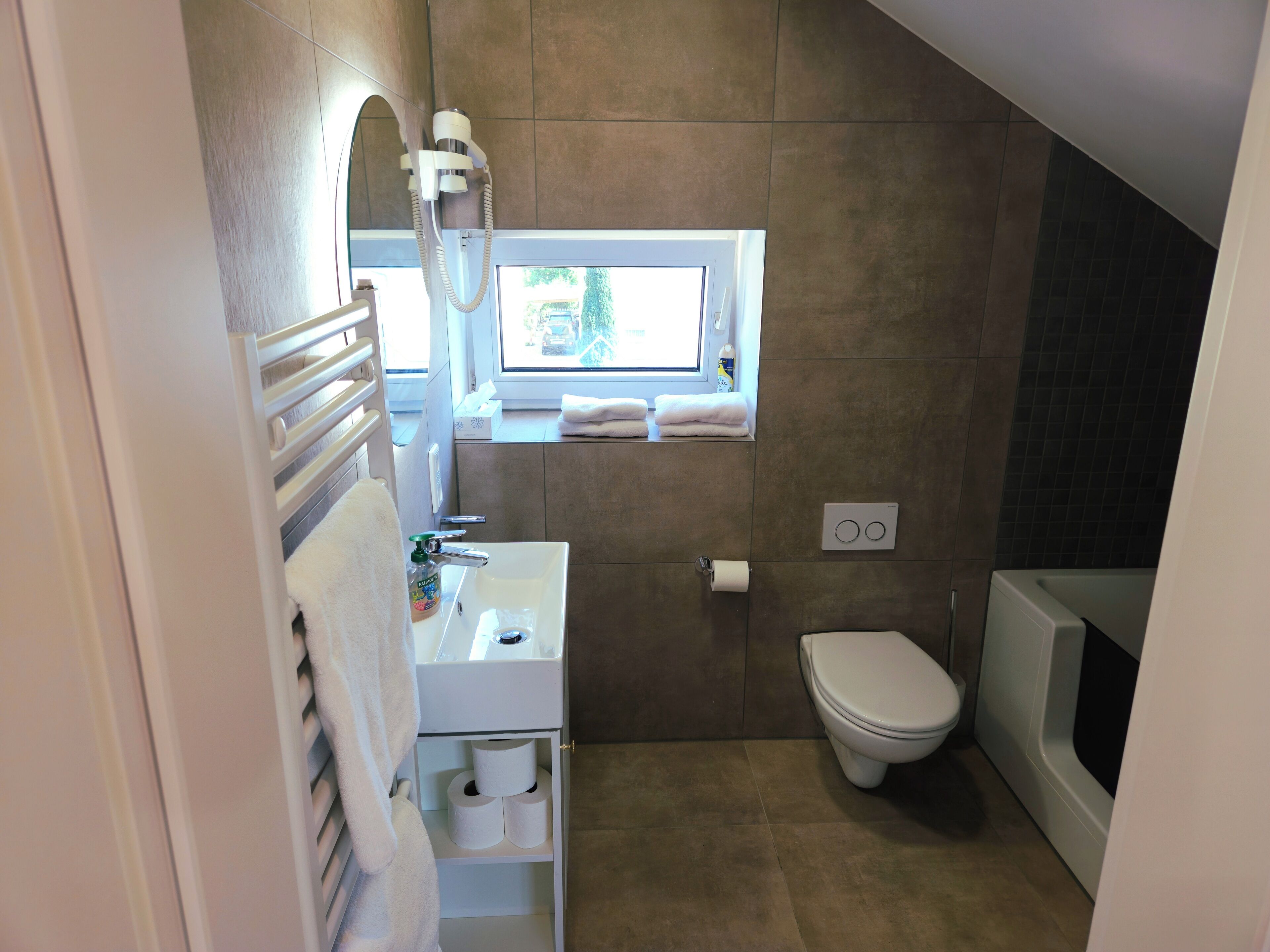 A modern bathroom with a toilet, sink, and shower.