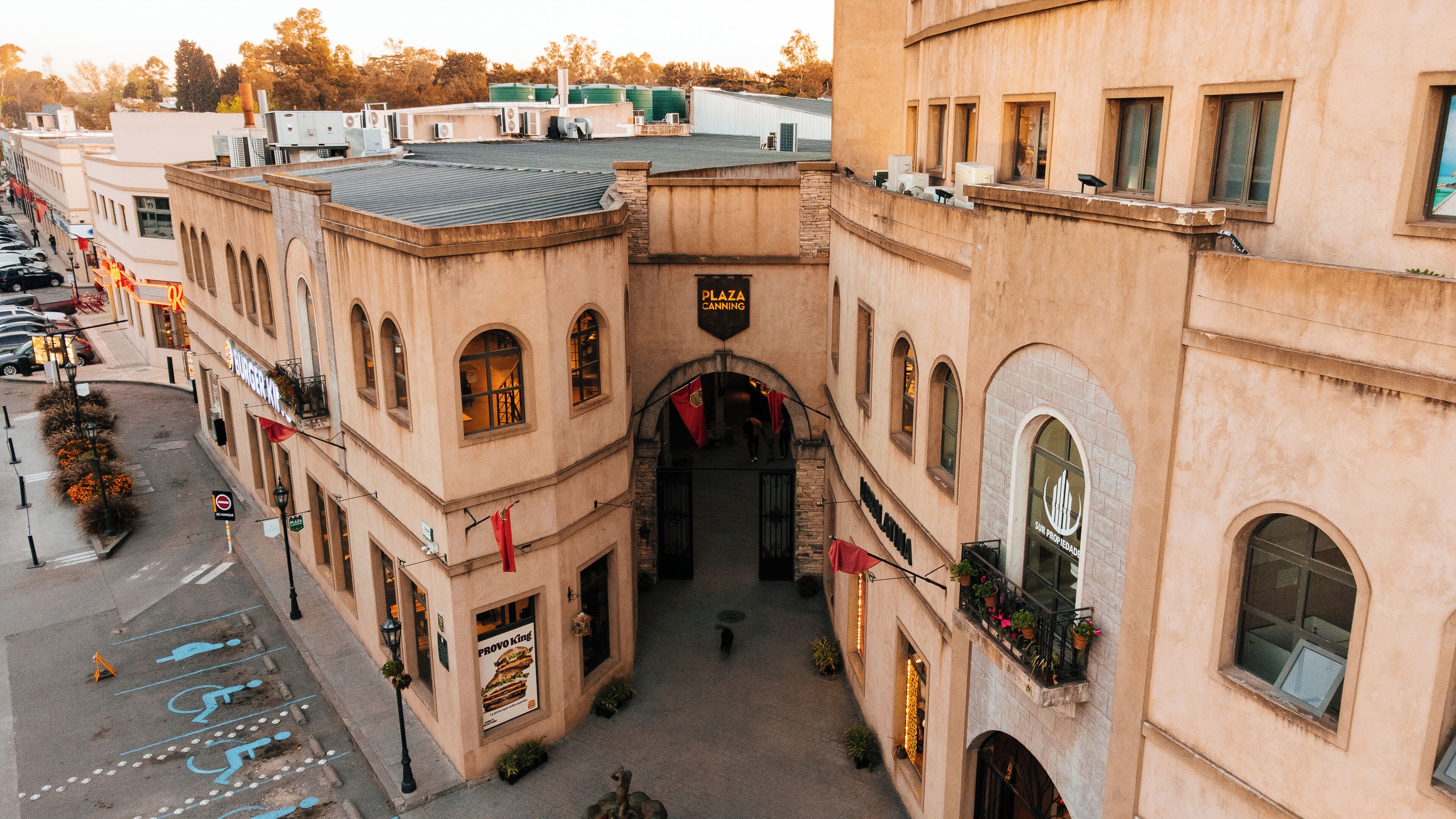 Um edifício histórico com um pátio central, janelas em arco e uma placa com a inscrição 'Plaza Canning'.