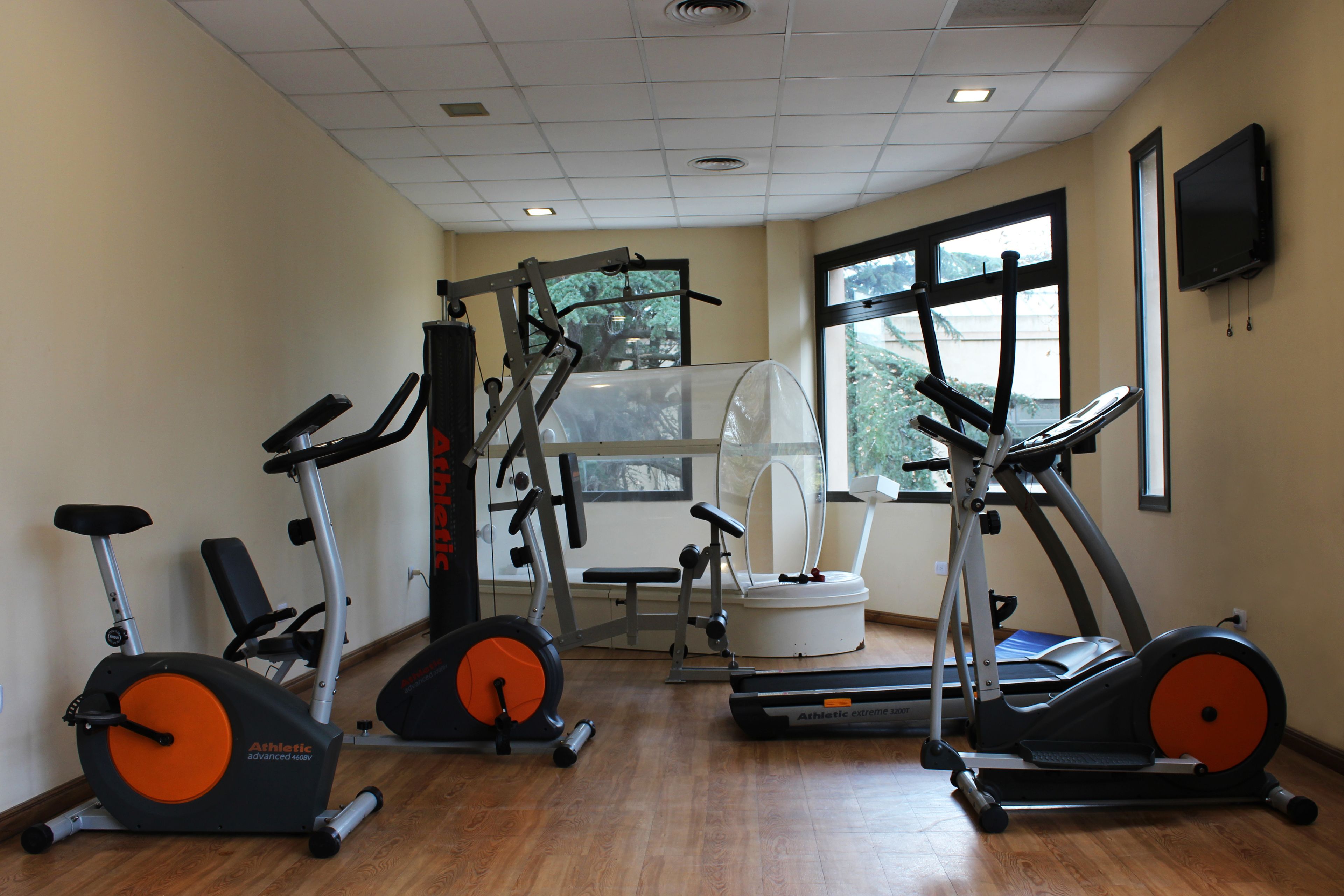 A gym with stationary bikes, treadmills, and a weight machine.