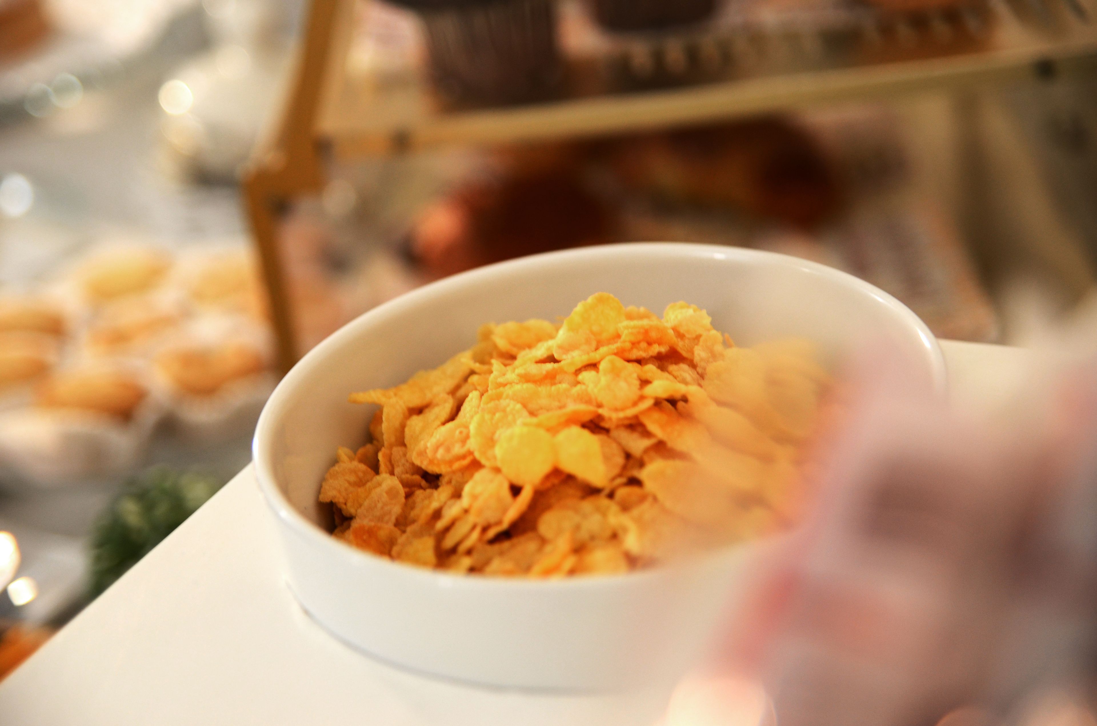 A bowl of cornflakes on a white plate.