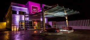 Vista frontal de la propiedad por la tarde o noche