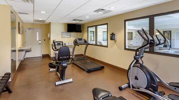 A fitness center with treadmills, an elliptical, and benches.